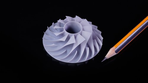 SLA miniature of compressor impeller next to a pencil for scale